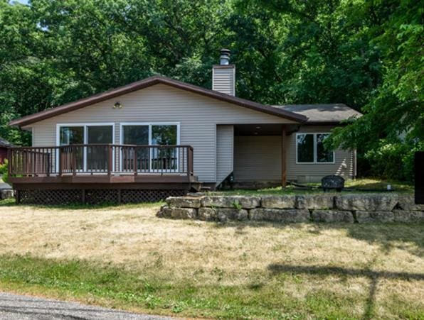 rear view of house with a wooden deck and a yard