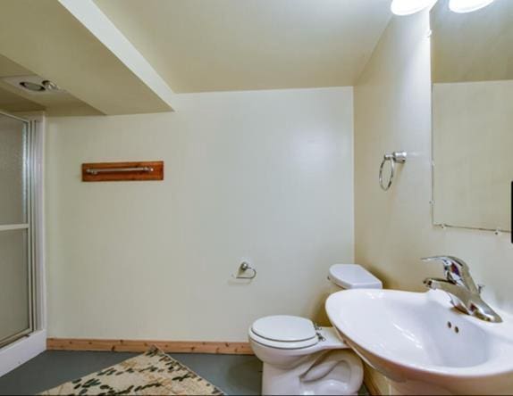 bathroom featuring walk in shower, sink, and toilet