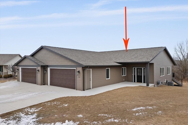 ranch-style house with a garage and cooling unit