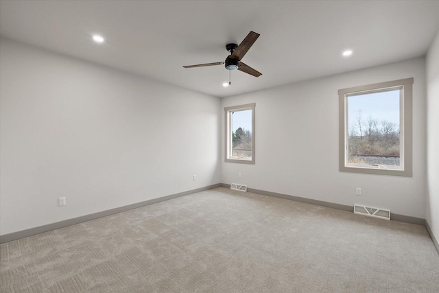 carpeted spare room with ceiling fan