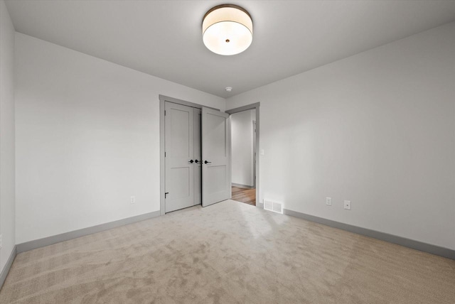 unfurnished room featuring light colored carpet