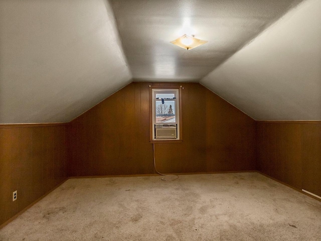 additional living space featuring lofted ceiling, cooling unit, and light carpet