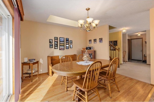 dining space featuring light hardwood / wood-style flooring and a chandelier