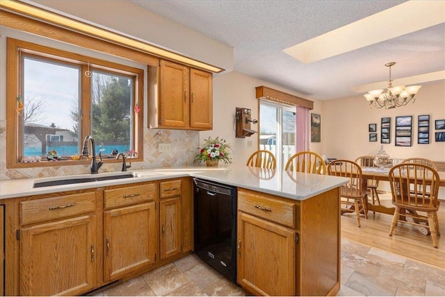 kitchen with sink, dishwasher, hanging light fixtures, plenty of natural light, and kitchen peninsula