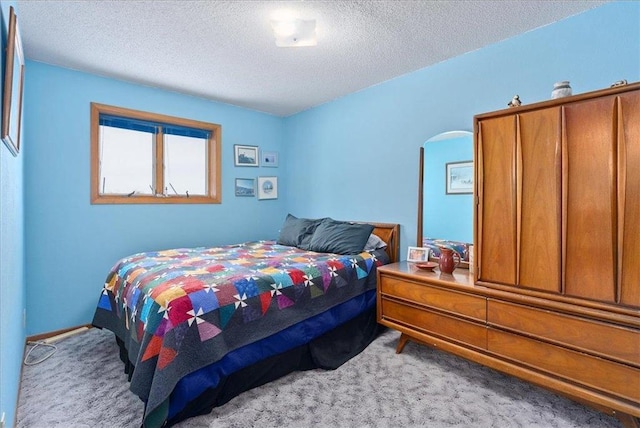 bedroom with light carpet and a textured ceiling