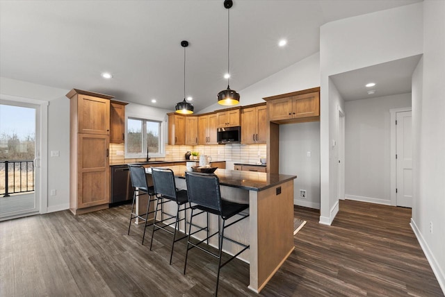 kitchen featuring dark hardwood / wood-style flooring, hanging light fixtures, dishwasher, and a kitchen island