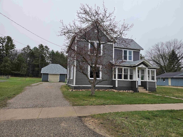 view of front of home with an outbuilding, a garage, and a front lawn