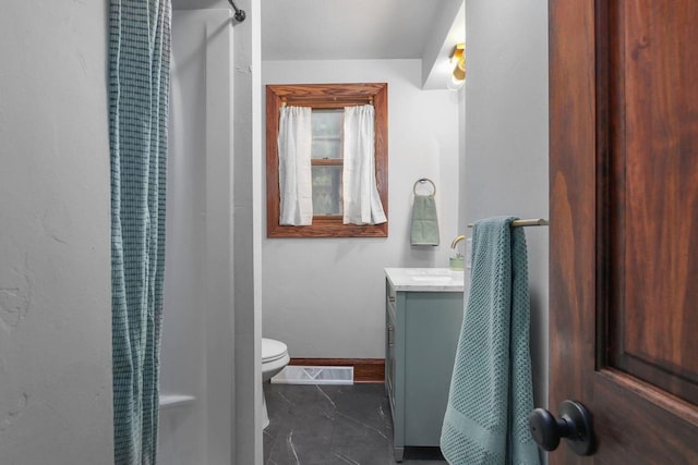 bathroom featuring vanity, toilet, and curtained shower