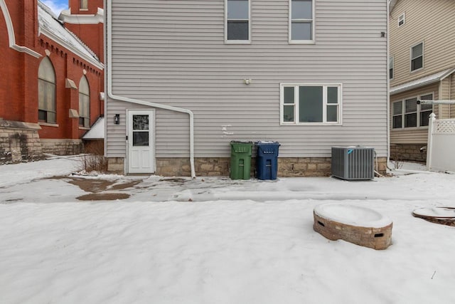 snow covered property featuring central AC