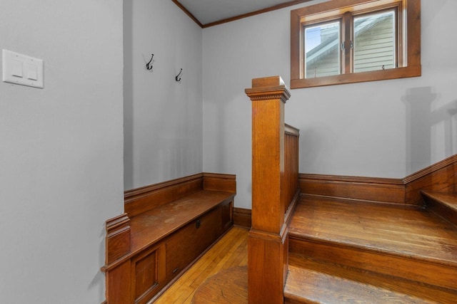 staircase with hardwood / wood-style flooring and crown molding