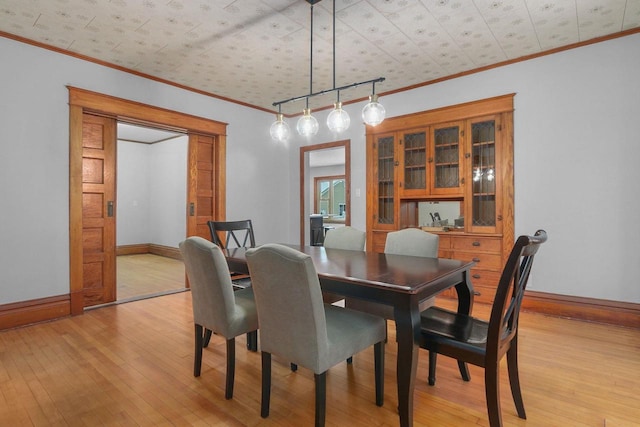 dining room featuring ornamental molding and light hardwood / wood-style floors