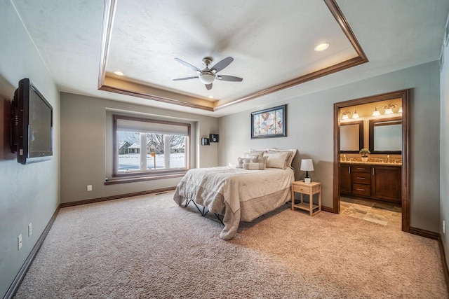 carpeted bedroom with connected bathroom, a raised ceiling, and ceiling fan