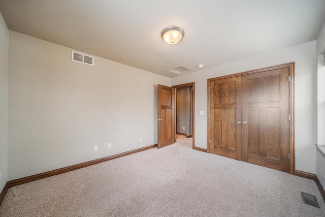 unfurnished bedroom with light carpet and a closet