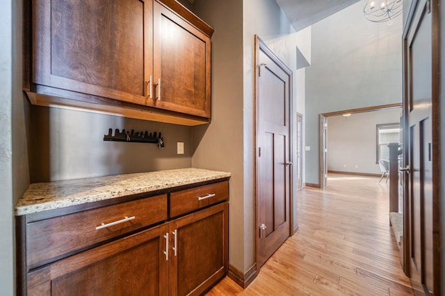 bar with light stone countertops and light hardwood / wood-style floors