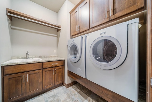 laundry room featuring sink, washing machine and dryer, and cabinets