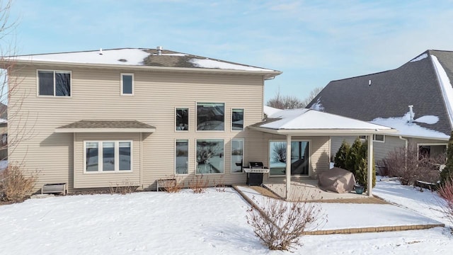 view of snow covered rear of property