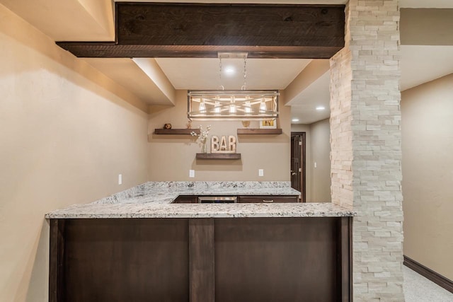 bar with pendant lighting and light stone counters