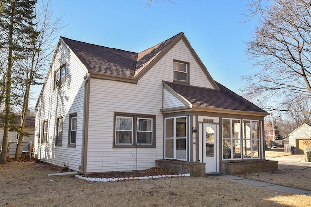 front facade with a front yard and a sunroom