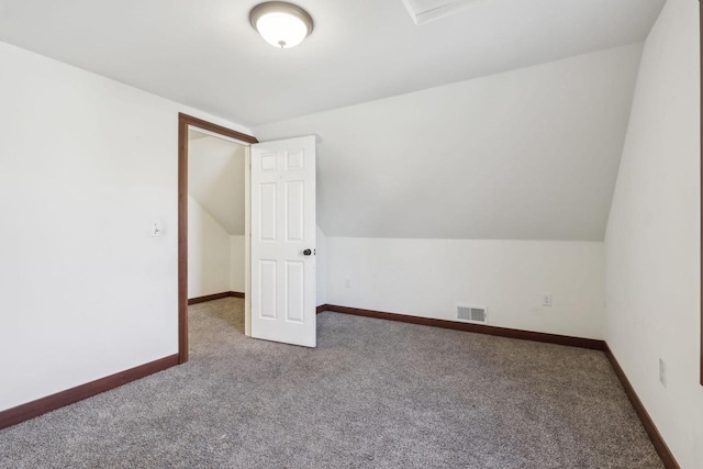 bonus room with vaulted ceiling and carpet flooring