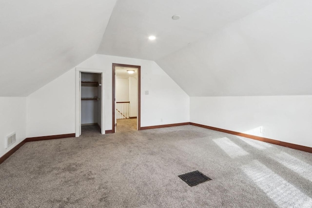 additional living space featuring carpet flooring and vaulted ceiling