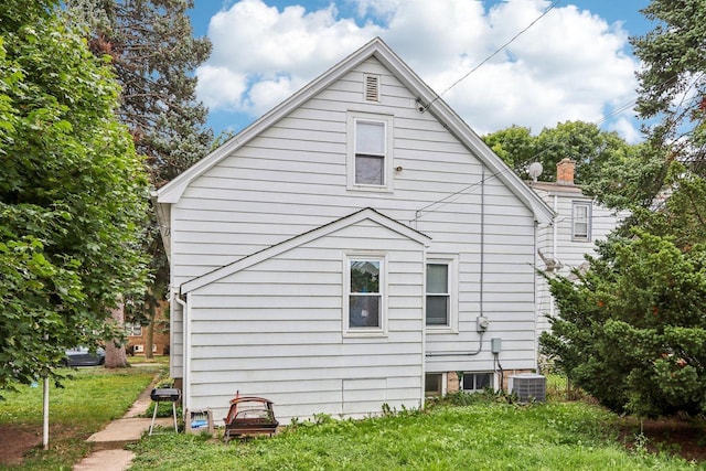 view of property exterior featuring a yard and central AC