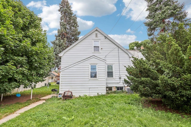 view of side of home with a yard and central AC