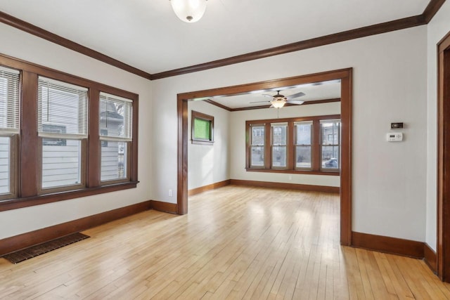 spare room with crown molding and light wood-type flooring