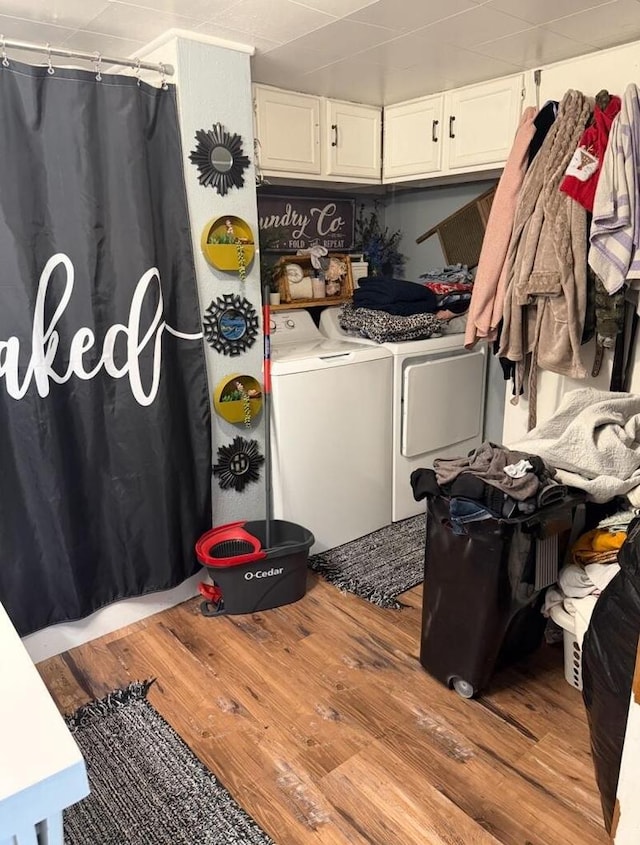 laundry area with washing machine and dryer and light wood-type flooring