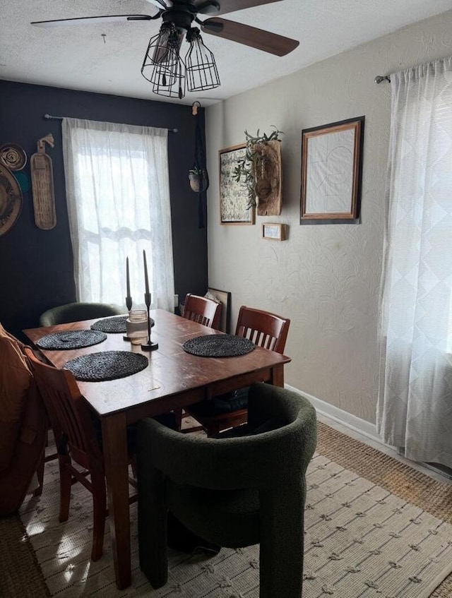 dining area featuring ceiling fan and a textured ceiling