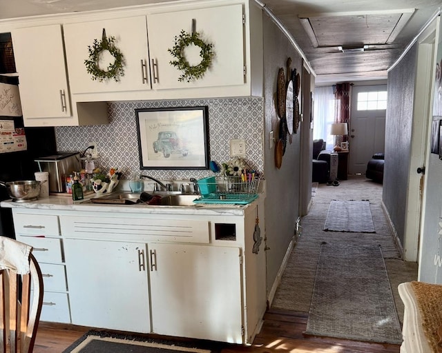 kitchen featuring sink, white cabinets, backsplash, and light wood-type flooring