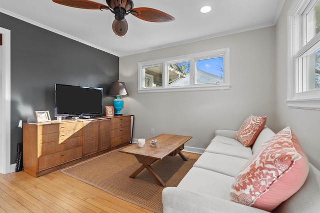 living room featuring ceiling fan, ornamental molding, and wood-type flooring