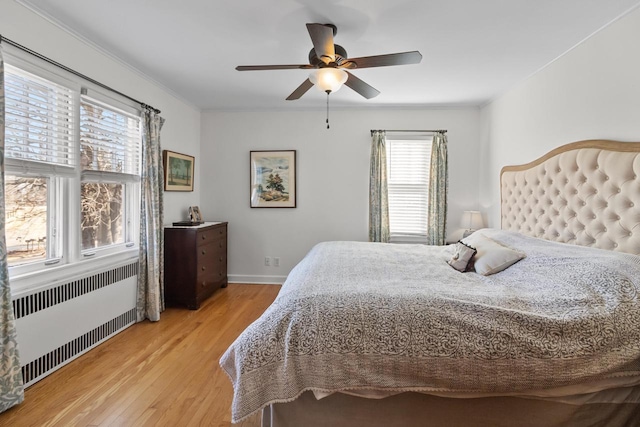 bedroom with crown molding, radiator, ceiling fan, and light hardwood / wood-style flooring