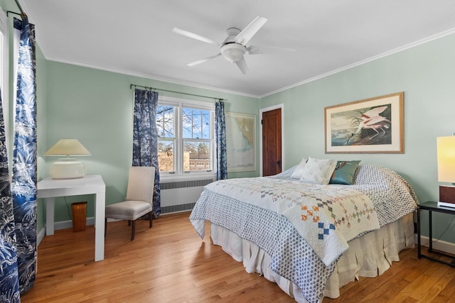 bedroom featuring crown molding, ceiling fan, radiator heating unit, and light hardwood / wood-style flooring