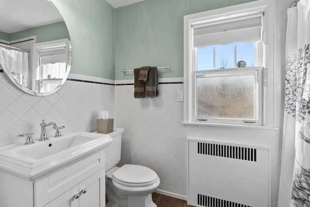 bathroom featuring tile patterned flooring, vanity, radiator heating unit, and toilet