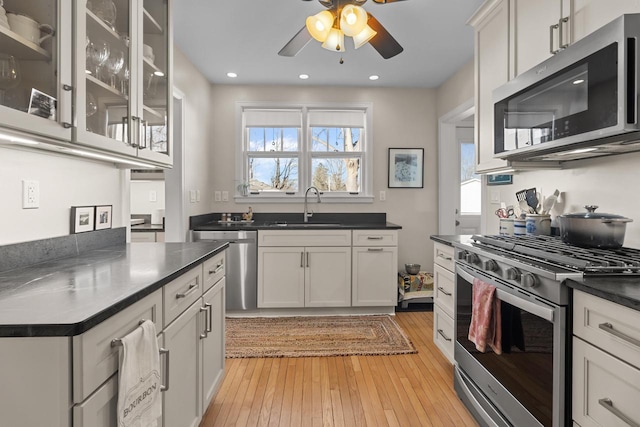 kitchen featuring ceiling fan, appliances with stainless steel finishes, sink, and light hardwood / wood-style floors