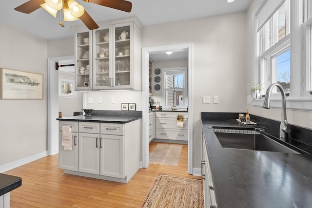 kitchen with sink, white cabinets, and light wood-type flooring