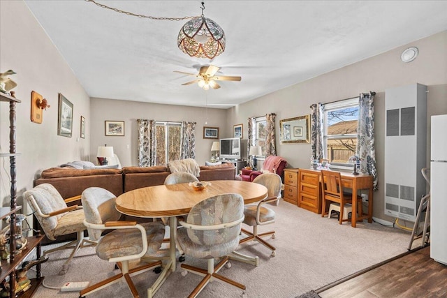 carpeted dining room with ceiling fan