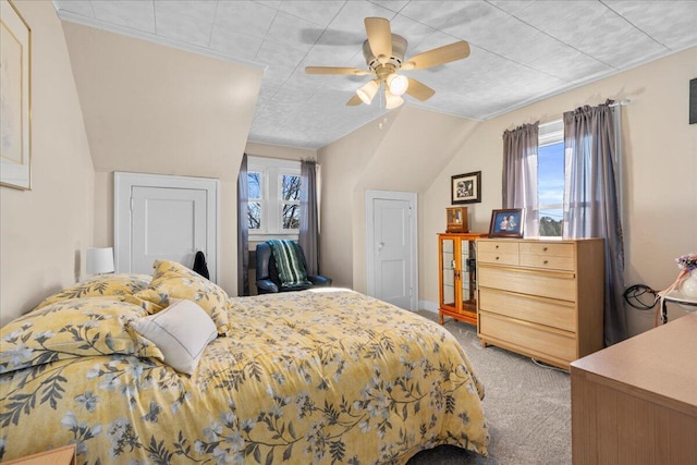 carpeted bedroom with ceiling fan, lofted ceiling, and multiple windows