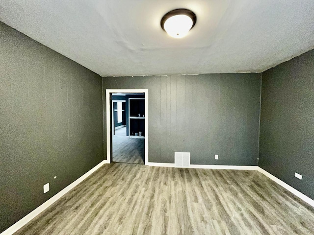 unfurnished room with hardwood / wood-style flooring