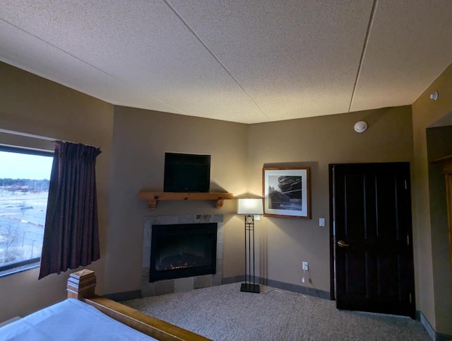 unfurnished bedroom with carpet floors, a tile fireplace, and a textured ceiling