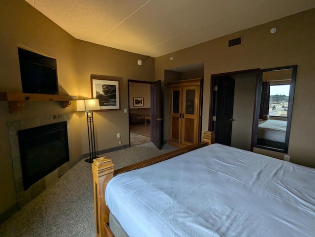 bedroom with a fireplace and carpet