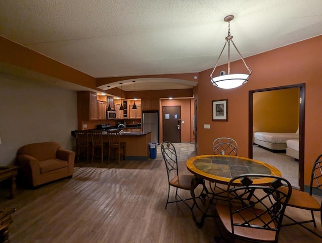 dining area featuring dark wood-type flooring and a textured ceiling