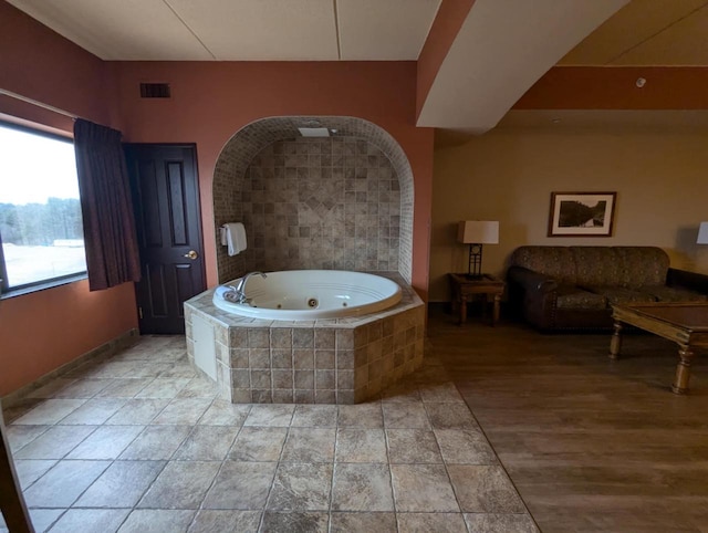 bathroom featuring tiled tub and hardwood / wood-style floors