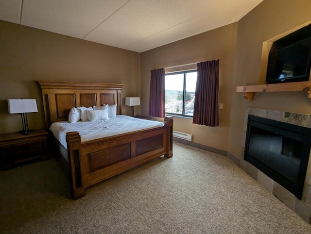 carpeted bedroom featuring a tile fireplace and a baseboard heating unit