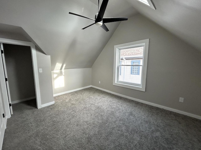 bonus room with dark colored carpet, vaulted ceiling, and ceiling fan