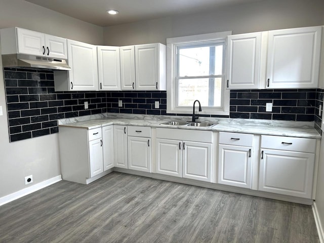 kitchen featuring sink, tasteful backsplash, light hardwood / wood-style flooring, light stone countertops, and white cabinets