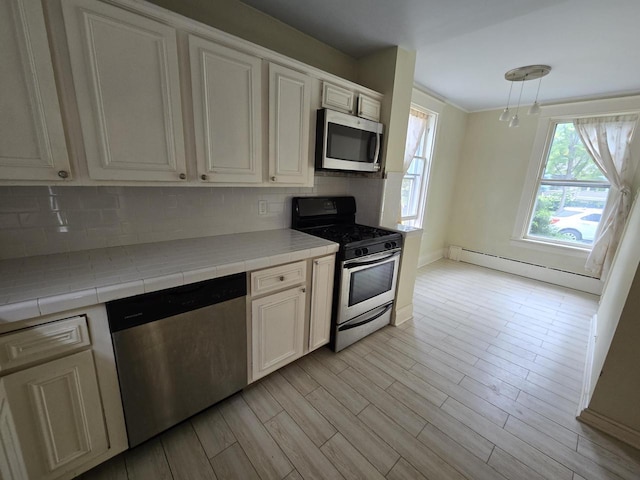 kitchen featuring baseboard heating, tile counters, white cabinets, stainless steel appliances, and backsplash