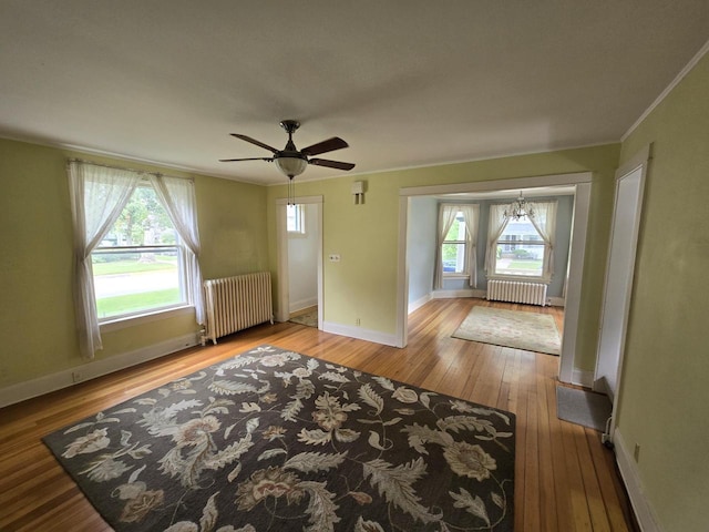 foyer with ceiling fan, crown molding, radiator heating unit, and wood-type flooring