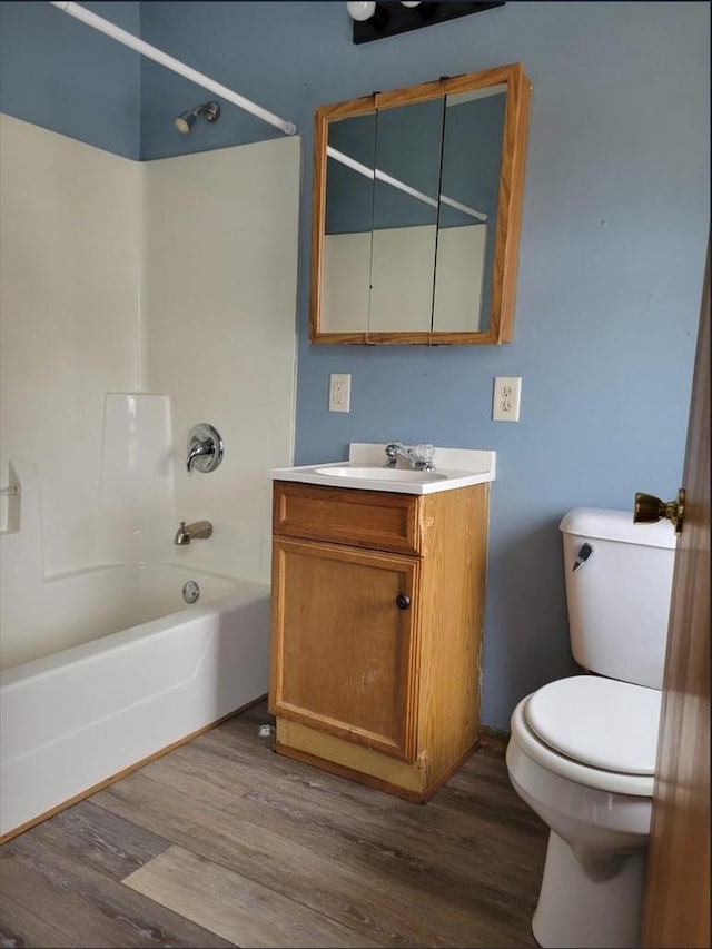 full bathroom featuring vanity, hardwood / wood-style flooring,  shower combination, and toilet