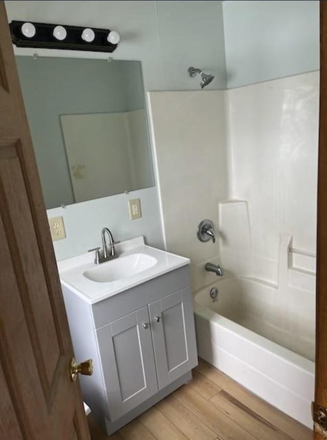 bathroom with shower / tub combination, vanity, and hardwood / wood-style floors